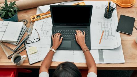 women at a desk working on laptop